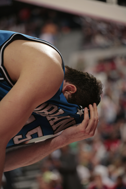 Hedo Turkoglu covers his nose with his jersey after being hit with an elbow of a Detroit Pistons player.